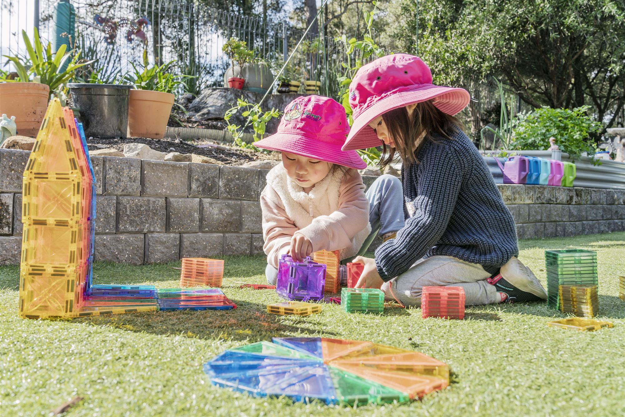Girls building blocks in garden